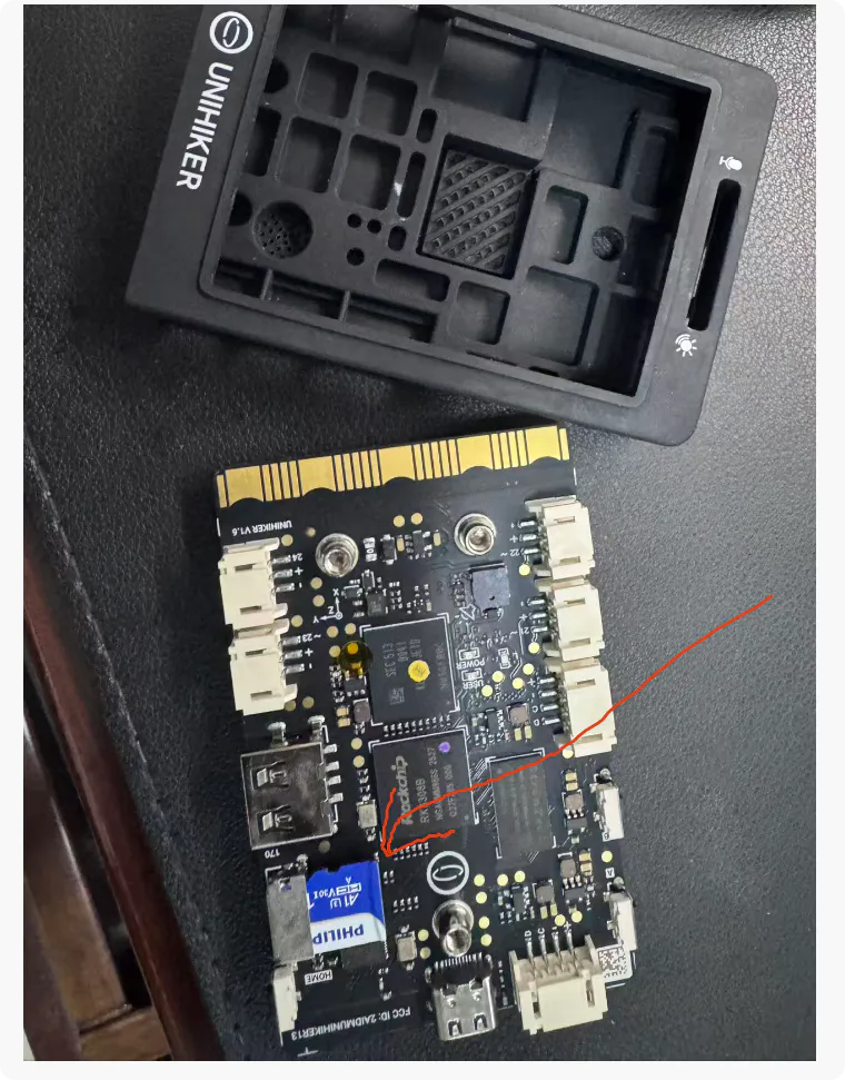 拆开保护壳后露出板载microSD卡槽，槽内插着一张SD卡，红笔圈出位置——正是它干扰了烧录流程