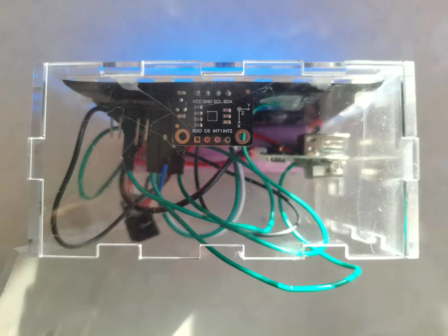 盒内特写：LIS2DW12加速度计模块、接线与充电口开孔